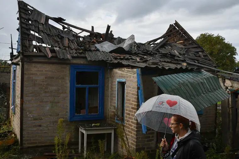 Local resident Ekaterina, 22, stands next to her home that was damaged after an overnight Russian attack in Kramatorsk, Ukraine, on Tuesday.