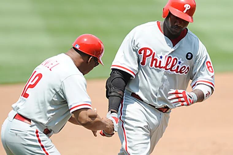 Ryan Howard is greeted by third base coach Juan Samuel after hitting a home run in the fourth. (AP Photo/Nick Wass)