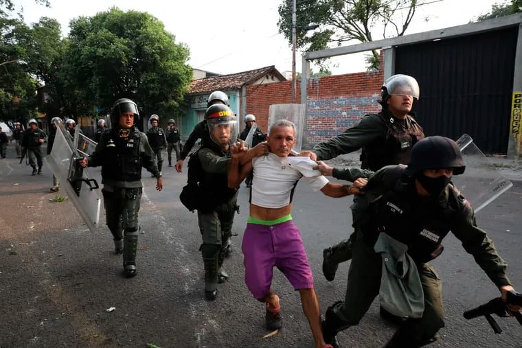 A man is detained during clashes with the Bolivarian National Guard in Urena, Venezuela, near the border with Colombia, Saturday, Feb. 23, 2019. Venezuela's National Guard fired tear gas on residents clearing a barricaded border bridge between Venezuela and Colombia on Saturday, heightening tensions over blocked humanitarian aid that opposition leader Juan Guaido has vowed to bring into the country over objections from President Nicolas Maduro.