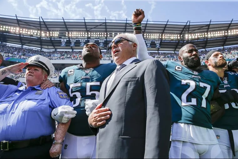Eagles owner Jeffrey Lurie stands with Eagles defensive end Brandon Graham and strong safety Malcolm Jenkins during the national anthem before Sunday’s game.