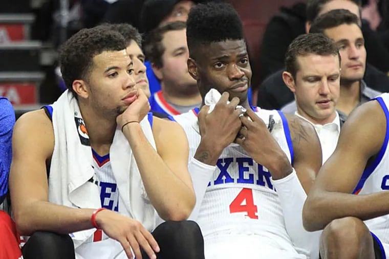 Michael Carter-Williams and Nerlens Noel sit on the bench as another loss. (Charles Fox/Staff Photographer)