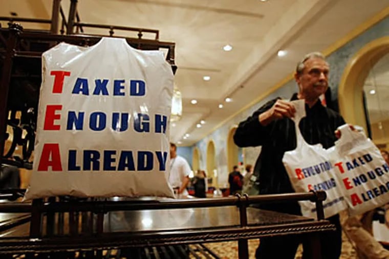 Bill Bruss of Winfield, Ill., gives away plastic bags in the vendor area at the National Tea Party convention in Nashville, Friday, Feb. 5, 2010. (AP Photo/Ed Reinke)