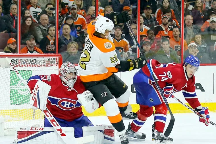 Flyers' Dale Weise gets hit by the puck against Canadiens' goalie Carey Price and Alexei Emelin.
