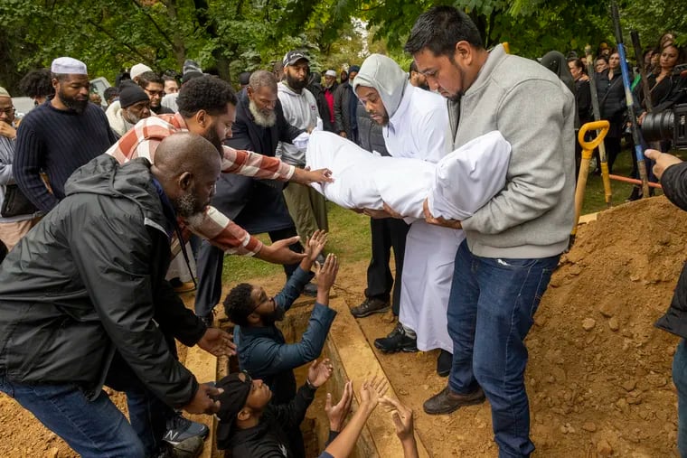 Carlos Elizalde carries his 14-year-old nephew Nicolas Elizalde to his grave at Friends Southwestern Burial Ground in Upper Darby on Wednesday.