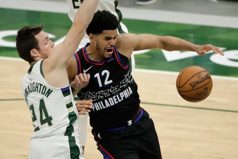 The Sixers' Tobias Harris (12) loses control of the ball while being defended by the Milwaukee Bucks' Pat Connaughton during the second half.