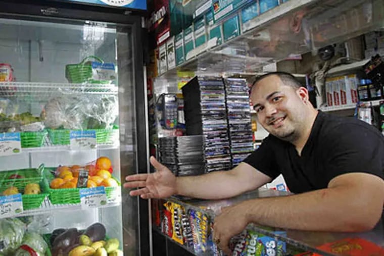 Jose Nunez of Robles Grocery recently qualified for a free refrigerator that allows him to sell yogurt, fruit salad and other perishables. (Alejandro A. Alvarez / Staff Photographer)