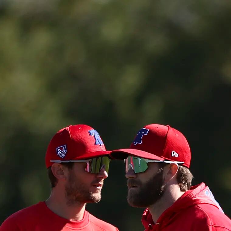 Trea Turner, left, and Bryce Harper warm up for their first official day of spring training.