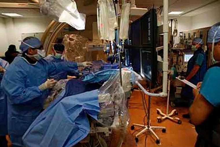 A surgical team gets ready at Thomas Jefferson University Hospital, one of two city hospitals working to reduce its rate of 'diversions' -- when ambulances are advised to steer clear because of a too-full emergency room. (Michael S. Wirtz / Staff / File)