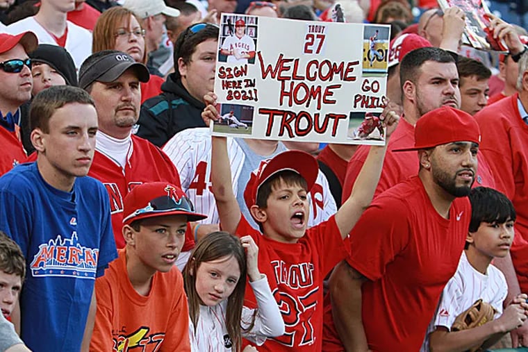 Fans attempt to get the attention of the Angels' Mike Trout. (Charles Fox/Staff Photographer)