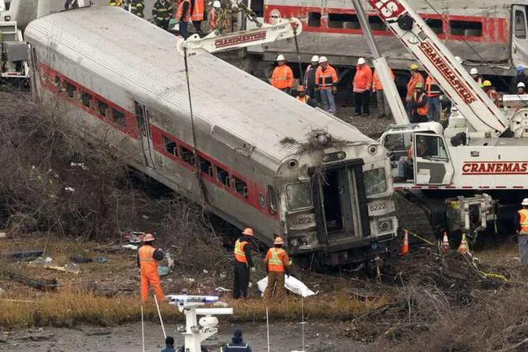 Cranes remove a railcar from near the river's edge in the Bronx. Four people were killed and more than 60 were injured.