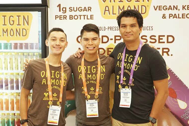 Owner of Almond Origin Jake Deleon, center, and team members at a natural foods trade show.
