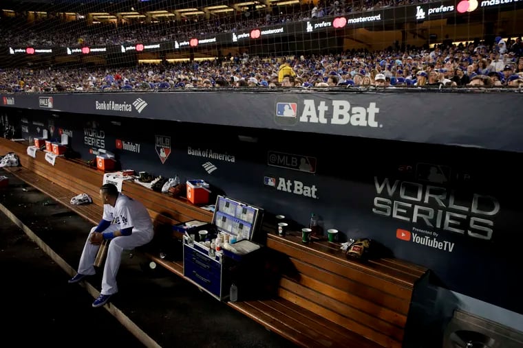Manny Machado sits in the Dodgers' dugout during the third inning in Game 5 of the World Series baseball game against the Boston Red Sox on Sunday, Oct. 28, 2018, in Los Angeles.