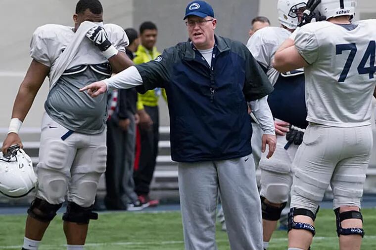 Penn State offensive line coach Herb Hand motions to players.