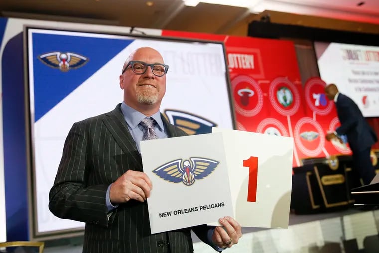 David Griffin, the New Orleans Pelicans' executive vice president of basketball operations, holds up placards after it was announced that the Pelicans had won the first pick during last year's draft lottery.
