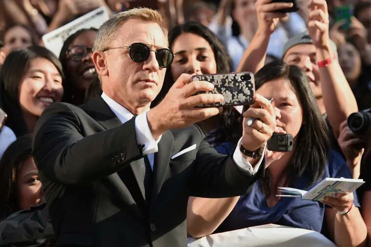 Daniel Craig takes a selfie with fans as he attends the premiere for "Knives Out" on day three of the Toronto International Film Festival at the Princess of Wales Theatre on Saturday, Sept. 7, 2019, in Toronto. (Photo by Evan Agostini/Invision/AP)