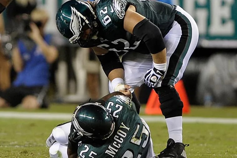 Philadelphia Eagles' Jason Kelce (62) checks on LeSean McCoy after McCoy was injured during the first half of an NFL football game against the Kansas City Chiefs, Thursday, Sept. 19, 2013, in Philadelphia. (AP Photo/Michael Perez)