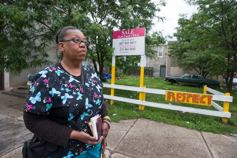 Charlene Pryor stands near her family’s lots on Susquehanna Avenue. Someone forged her late mother’s signature on a deed to steal the lots and offer them for resale.