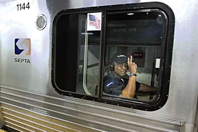 A SEPTA engineer signals with two fingers as builds speed to leave the 8th St. station on the Market-Frankford line, May 22, 2013.  ( DAVID M WARREN / Staff Photographer )