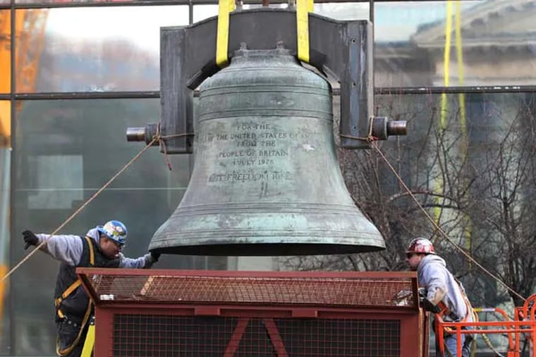 Kevin Dukes, right, and Michael Reagan, left, guide the Bicentennial Bell down, as it was lowered by a crane, into a storage box, in 2013. The Bicentennial Bell, a gift from Queen Elizabeth II to the American people, was moved from its home in the bell tower of the old park visitor center and placed in storage.