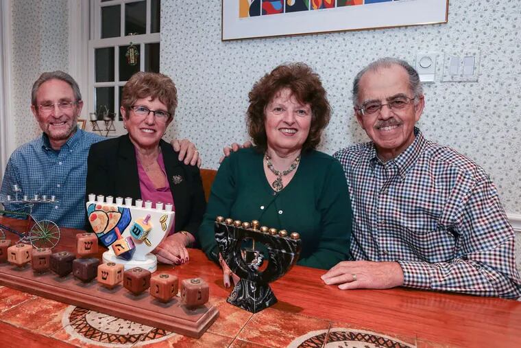 The Spitz/Lodish home in Bala Cynwyd a place perfect for Hanukkah celebrations. (l-r)  Len & Susan Lodish and Gloria and Bob Spitz, with menorahs.  ( STEVEN M. FALK / Staff Photographer )