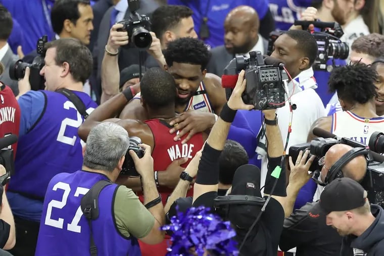 Joel Embiid of the Sixers hugs Dwyane Wade of the Heat after their playoff series at the Wells Fargo Center on Tuesday.
