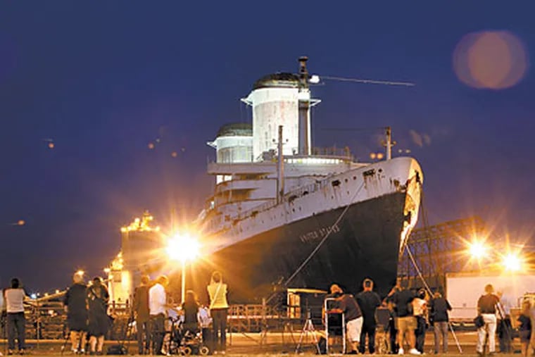 Hundreds of enthusiaists watch as the SS United States is lit up after sunset Thursday. Philadelphia philanthropist H.F. "Gerry" Lenfest will donate up to $5.8 million to help save the ship. (David Swanson / Staff Photographer)