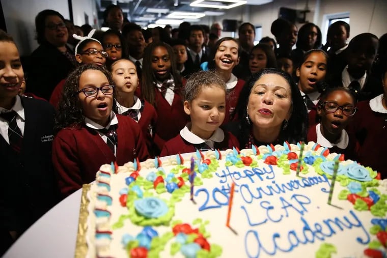 Founder Gloria Bonilla-Santiago, center right, gets help blowing out the candles on a cake at LEAP Academy Charter School in Camden on September 19, 2017. LEAP Academy is celebrating it’s 20th anniversary.