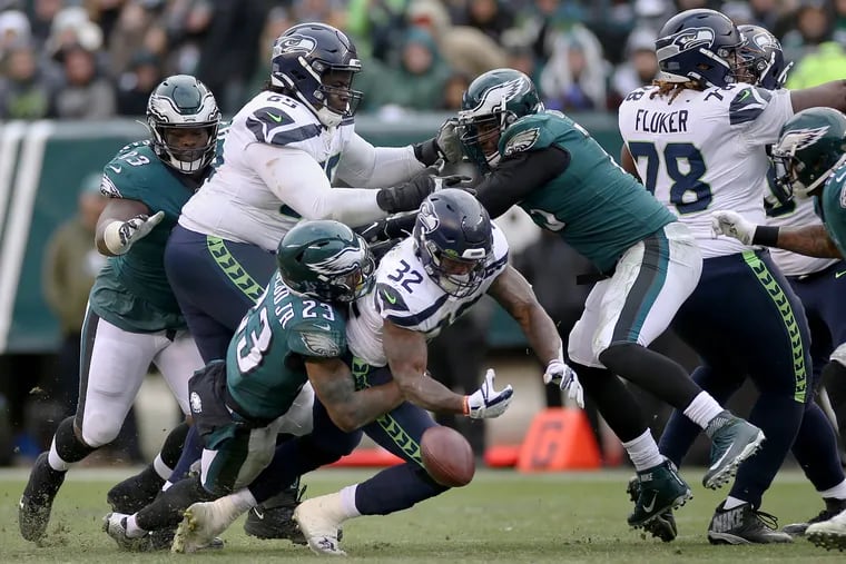 Eagles safety Rodney McLeod (23) forces a fumble by Seattle Seahawks running back Chris Carson (32) during a game at Lincoln Financial Field in Philadelphia on Sunday, Nov. 24, 2019. The Eagles lost 17-9.