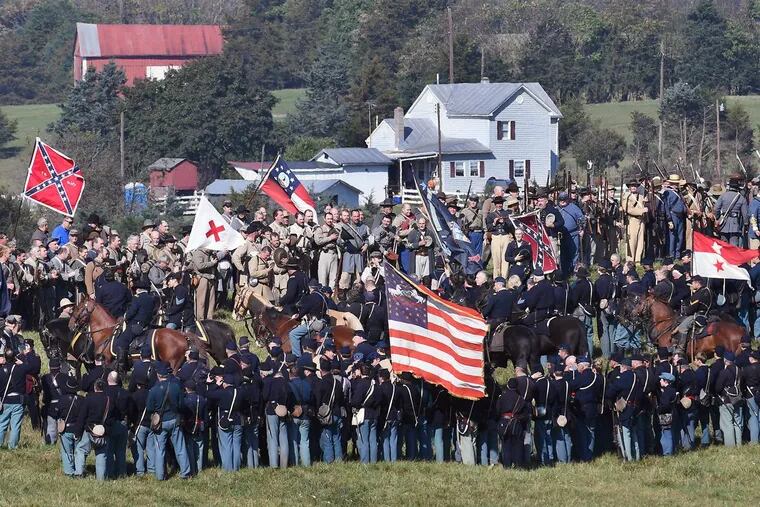 Participants stand together following a reenactment of the Battle of Cedar Creek on Sunday in Middletown, Va. Reenactors chanted “U.S.A.” after their mock battle.