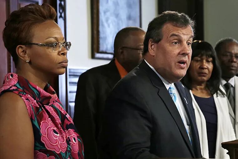 Camden, N.J. Mayor Dana Redd, left, and other community leaders, listen Wednesday, July 30, 2014, in Trenton, N.J., as New Jersey Gov. Chris Christie, center at podium, talks about his decision to hold a special legislative session on Thursday to try to persuade lawmakers to adopt an overhaul of the state's bail system. The proposed changes would give judges discretion to keep those considered dangerous behind bars and to release minor offenders even if they can't afford bail. (AP Photo/Mel Evans)