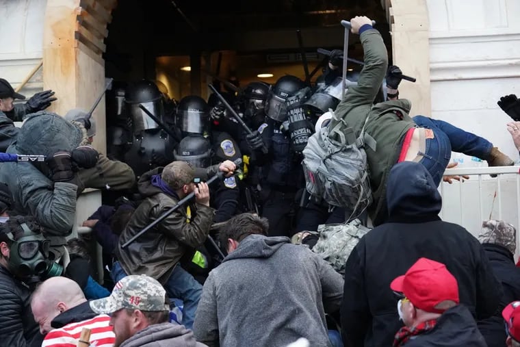 Pro-Trump protestors struggle with Capitol Police to try and take control of a door that is guarded by police at the U.S. Capitol Building, Jan. 6, 2021, in Washington, D.C. The United States Capitol Building was breached by thousands of Trump demonstrators.
