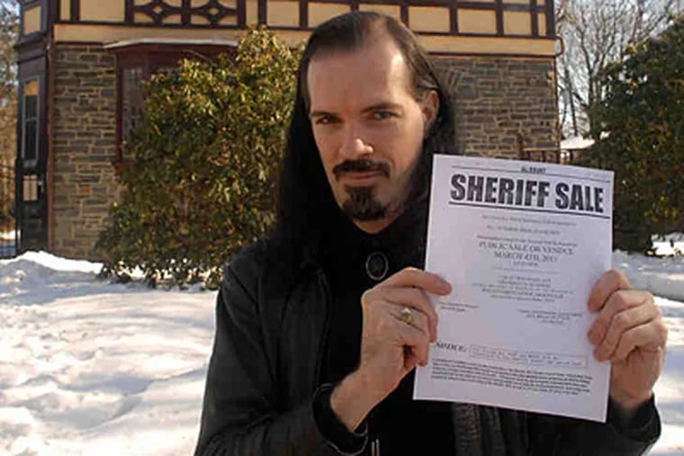Patrick Rodgers at his Wynnefield Heights home with the &quot;sheriff sale&quot; declaration against the mortgage company. (Tom Gralish / Staff Photographer)