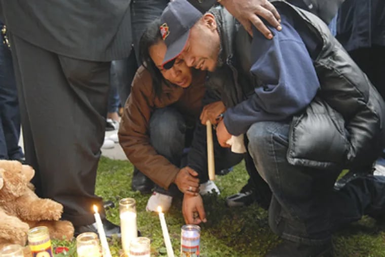 Israel Laboy, father of Robel Laboy who was killed Friday, is comforted at a candlelight vigil at Fourth and Ward streets on Saturday in Chester. (AP Photo/Delaware County Daily Times, Eric Hartline)