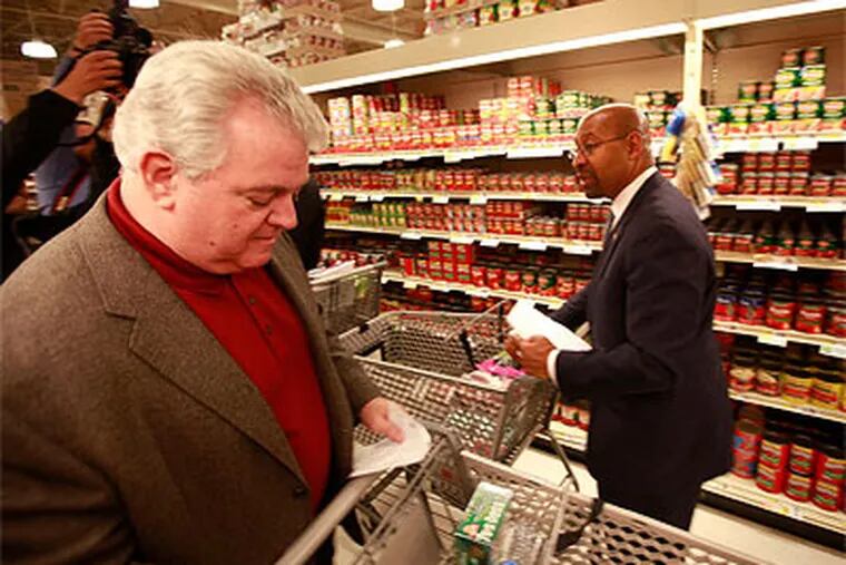 U.S. Rep. Bob Brady (left) and Philadelphia Mayor Michael Nutter try to shop for less than $35, the weekly limit of food-stamp purchases. (David Swanson / Staff Photographer)