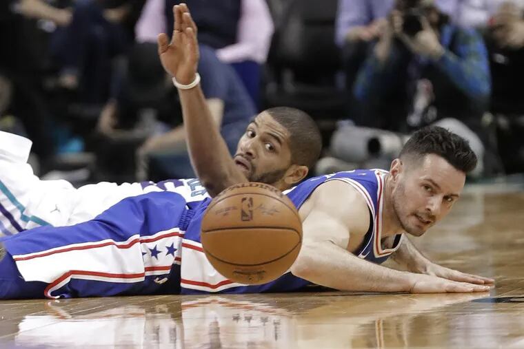 The 76ers' JJ Redick, front, and the Hornets' Nicolas Batum  chase a loose ball during the second half.
