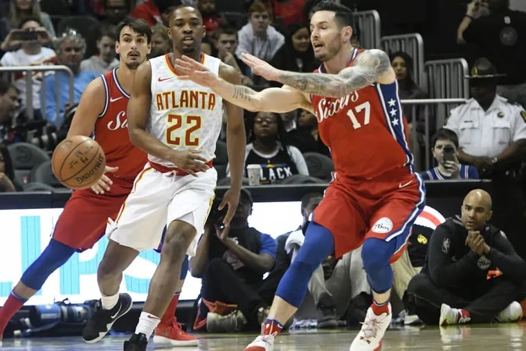 Sixers’ guard JJ Redick passes in front of Atlanta Hawks guard Isaiah Taylor (22) during the first half of an NBA basketball game on Friday.