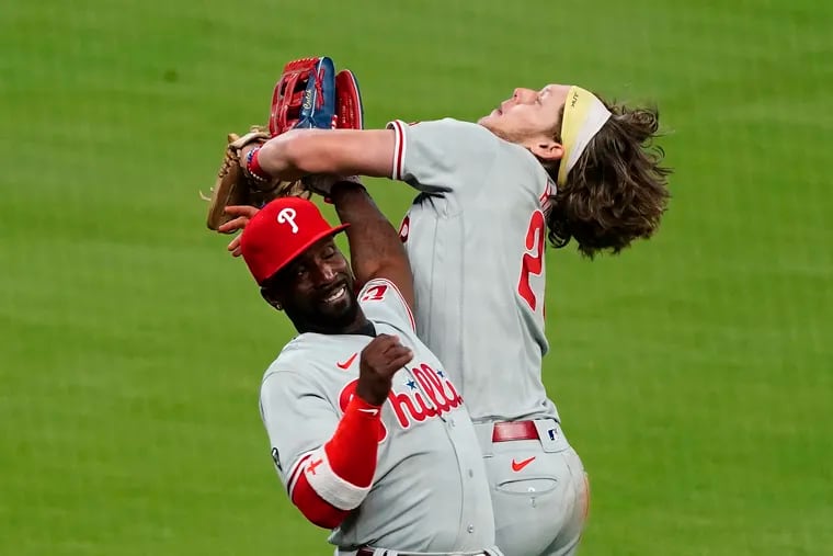 Phillies third baseman Alec Bohm (28) collides with left fielder Andrew McCutchen as he catches a foul pop-up by Atlanta's Ozzie Albies.