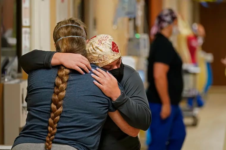 An ICU nurse hugs the sister of a COVID-19 patient she had been caring for, who had just died, inside a COVID unit in Shreveport, La., Aug. 18, 2021.