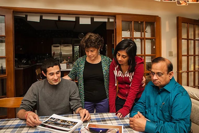 The Tripathi family of Bryn Mawr sorts through over 800 images of hands bearing words of support, received through social media after Sunil Tripathi's death in April 2013. ( Matthew Hall / Staff Photographer )