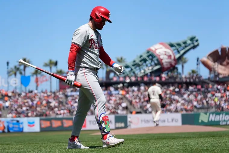 Bryce Harper of the Phillies walks back to the dugout after striking out during the first inning against the Giants.
