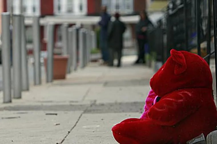 The scene where Halim Lindsey was gunned down in West Philadelphia. Lindsey was shot 12 times on Redfield Street. A memorial rests where Lindsey was
killed. (David Maialetti / Staff Photographer)