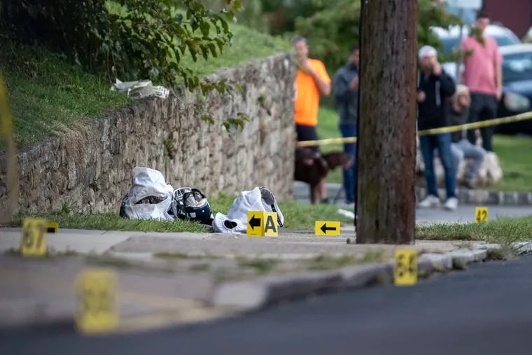 Dropped football equipment and evidence markers on the scene behind Roxborough High School in Philadelphia on Sept. 27.  A 14-year-old boy was killed and four others were injured in the shooting.