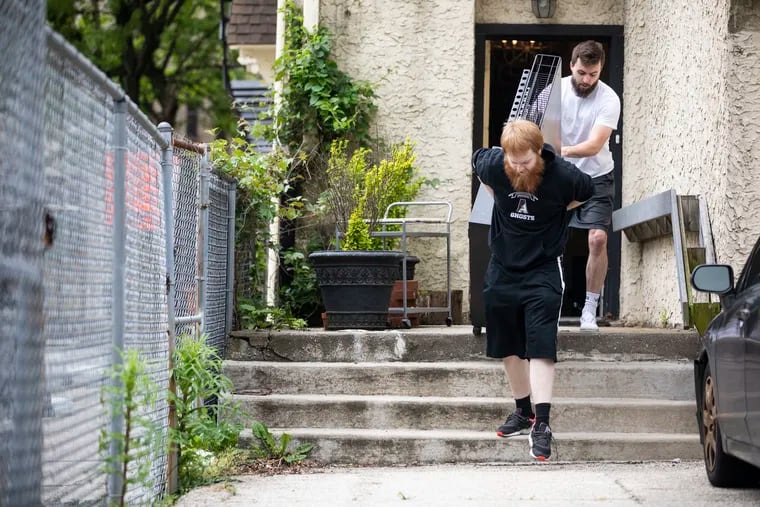 Brent Flynn, 19, and Julian Flynn, 23, move furniture out to the street at Culture Hair Studio in Philadelphia, Pa. on Sunday, May 24, 2020. After 16 years in business, Culture Hair Studio is closing.