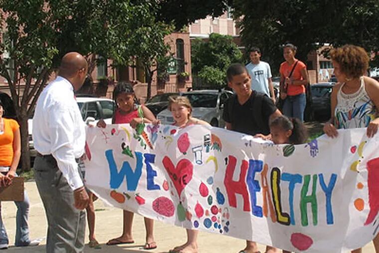 A school class greets Mayor Nutter with a poster saying "We love Healthy" outside the Farmers Market in Norris Square in North Philadelphia. (Photo by Michael Brocker)