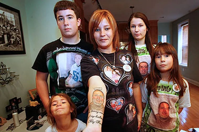 Danielle Romanoff-Maniscalco (center), with her children, displays a tattoo of Rocco.(Alejandro A. Alvarez / Staff Photographer)