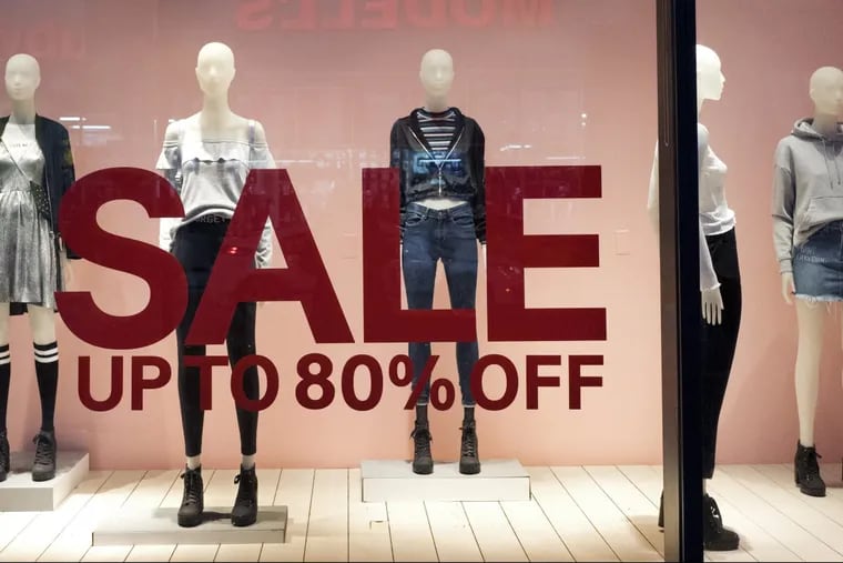 An H&amp; M store window advertises a sale, in New York. Store sales have slowed and forced the company to change its strategy.