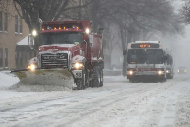 A plow truck clears snow on westbound Germantown Ave as SEPTA buses follow close behind in order to navigate the slippery streets on Thursday, Jan. 4, 2018.