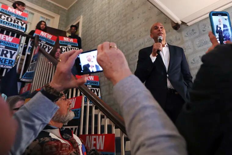 FILE - In this March 15, 2019, file photo, Democratic presidential candidate Sen. Cory Booker, D-N.J., addresses a gathering as guests take photographs with their phones at a house party during a campaign stop in Claremont, N.H. The Iowa caucus is still 10 months away, but the Democratic primary campaign is already an all-out sprint _ passing eye-popping markers for campaign activity and voter engagement. (AP Photo/Charles Krupa, File)
