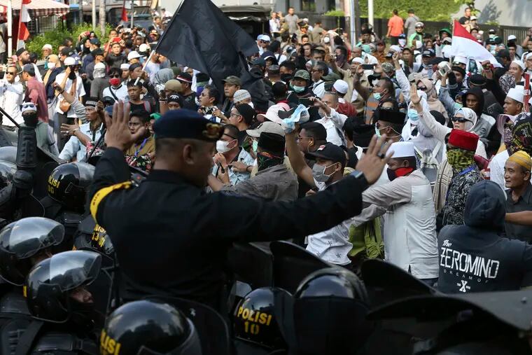 Indonesian police officers block supporters of Indonesian presidential candidate Prabowo Subianto during a rally outside the Elections Supervisory Agency (Bawaslu) building in Jakarta, Indonesia, Tuesday, May 21, 2019. Indonesia's President Joko Widodo has been elected for a second term, official results showed Tuesday, in a victory over a would-be strongman who aligned himself with Islamic hardliners.
