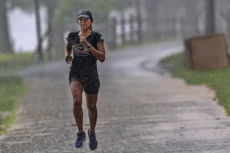 A jogger slogs through pouring rain early Sunday morning in Fairmount Park. 